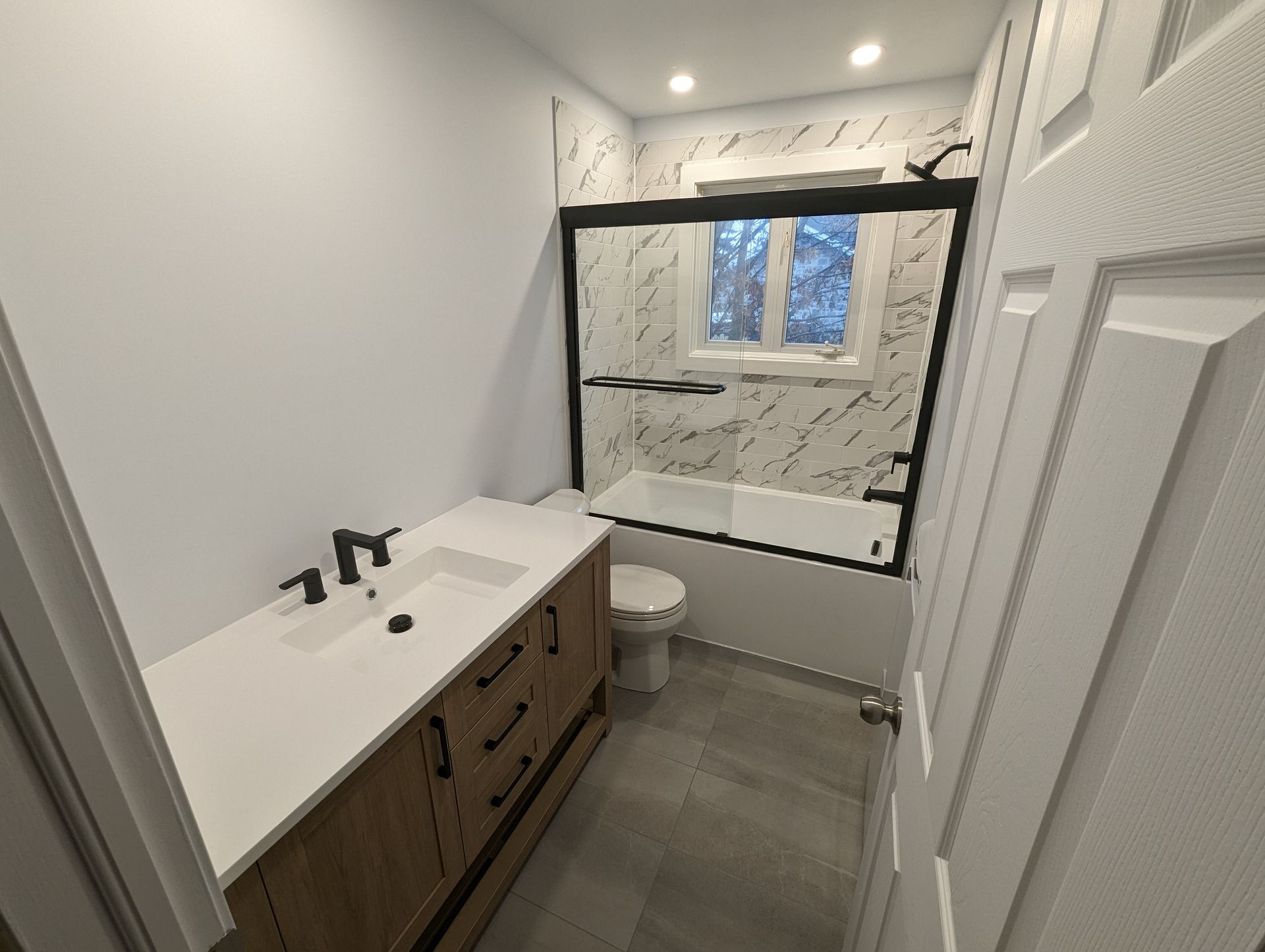 Une salle de bain avec lavabo, toilettes et baignoire.