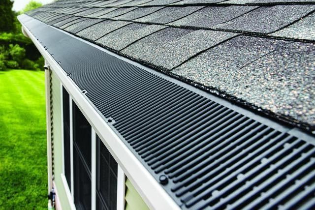 Black gutter guard installed on a roof, protecting a gutter from debris.