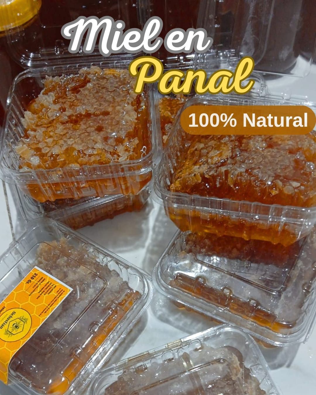 En la exposición se exhiben envases de miel dorada con las etiquetas “Miel en Panal” y “100% Natural”.