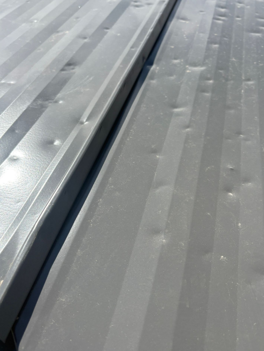 Impact damage on building siding in Lansing, IA.