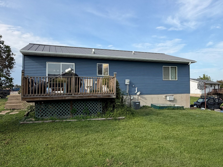 Rear exterior showing blue siding and a wooden deck in Lansing, IA.