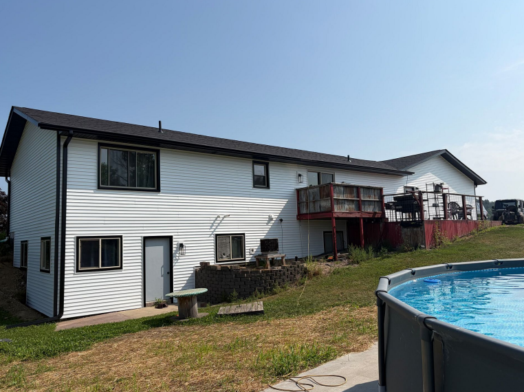Home exterior showing new white siding and black trim in Lansing, IA.