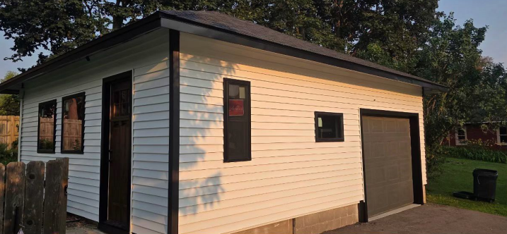 New white siding and dark trim on a renovated building in Lansing, IA.