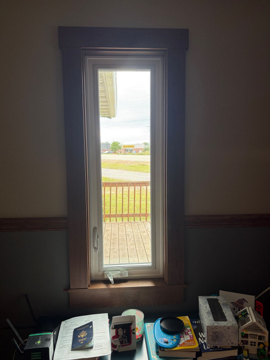 New window installation with wooden trim in Lansing, IA.