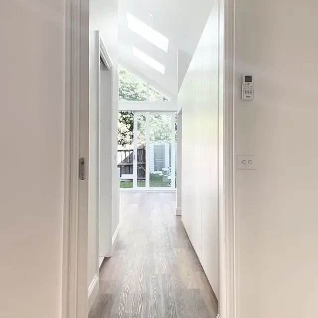 A Long Hallway in a House With Hardwood Floors and White Walls — Evoke Building Group In Ballarat, VIC