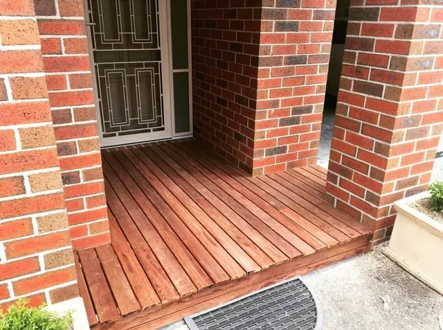 A Brick Building With a Wooden Deck in Front of It — Evoke Building Group In Maryborough, VIC