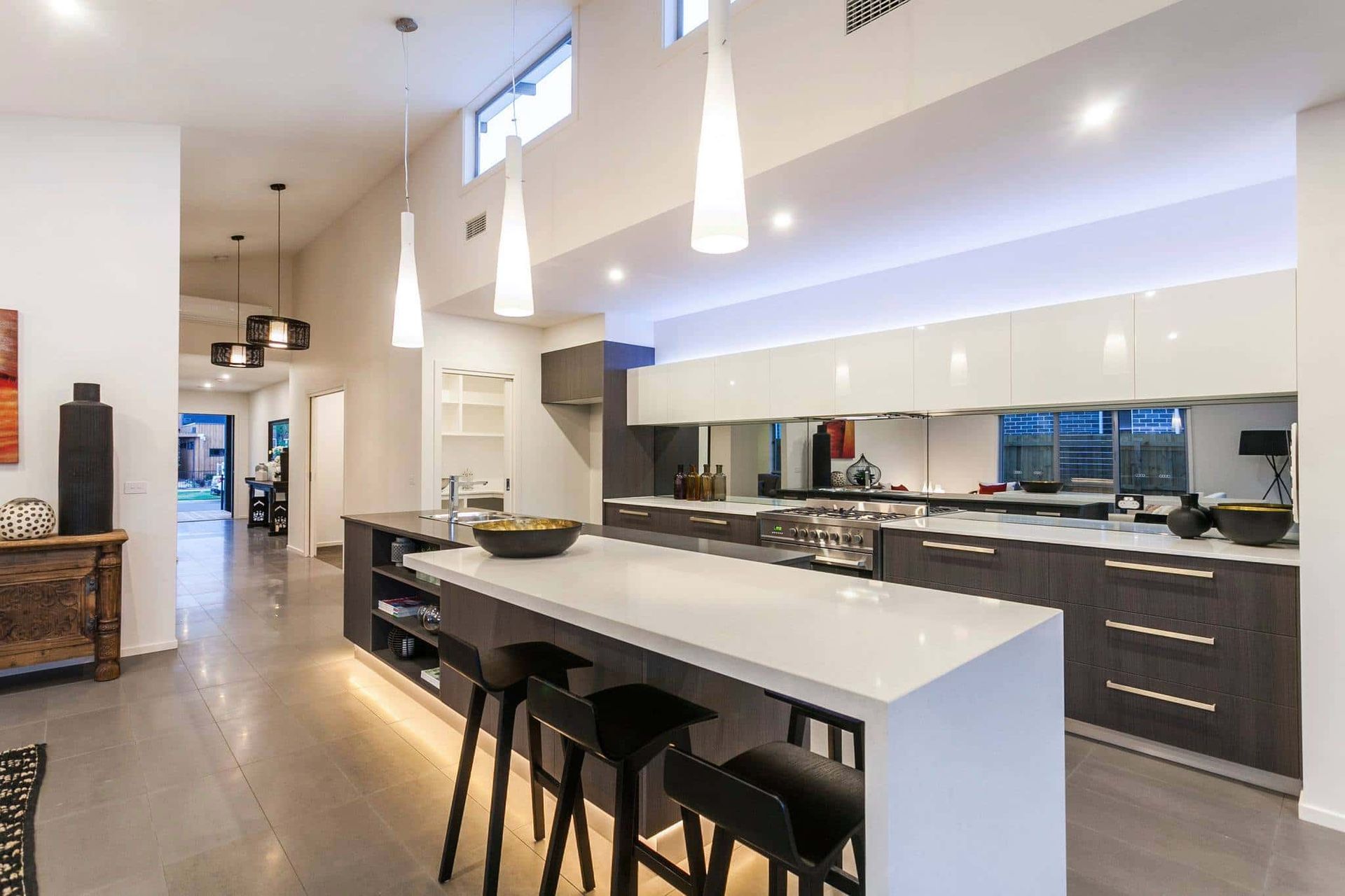 A Modern Kitchen With a Large Island and Stools — Evoke Building Group In Geelong, VIC