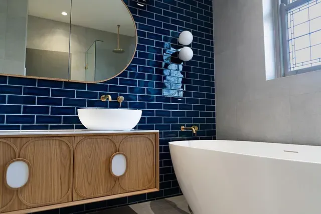 A Bathroom With Blue Tiles , a Sink and a Bathtub — Evoke Building Group In Ballarat Central, VIC