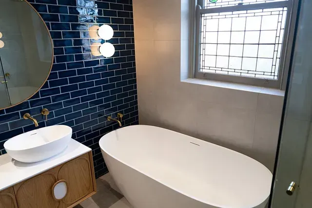 A Bathroom With a Tub , Sink , Mirror and Window — Evoke Building Group In Ballarat Central, VIC