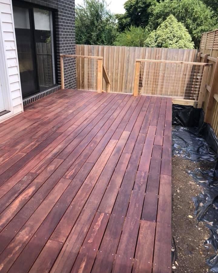 A Wooden Deck With a Wooden Fence and a Brick Building in the Background — Evoke Building Group In Ballarat Central, VIC