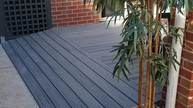 A Bamboo Tree is Sitting on a Wooden Deck Next to a Brick Building — Evoke Building Group In Ballarat Central, VIC