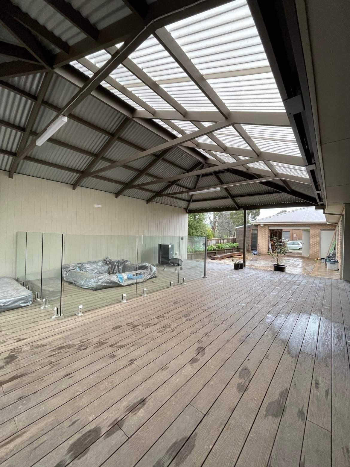 A Wooden Pergola is Sitting on Top of a Patio With a Table and Chairs Underneath It