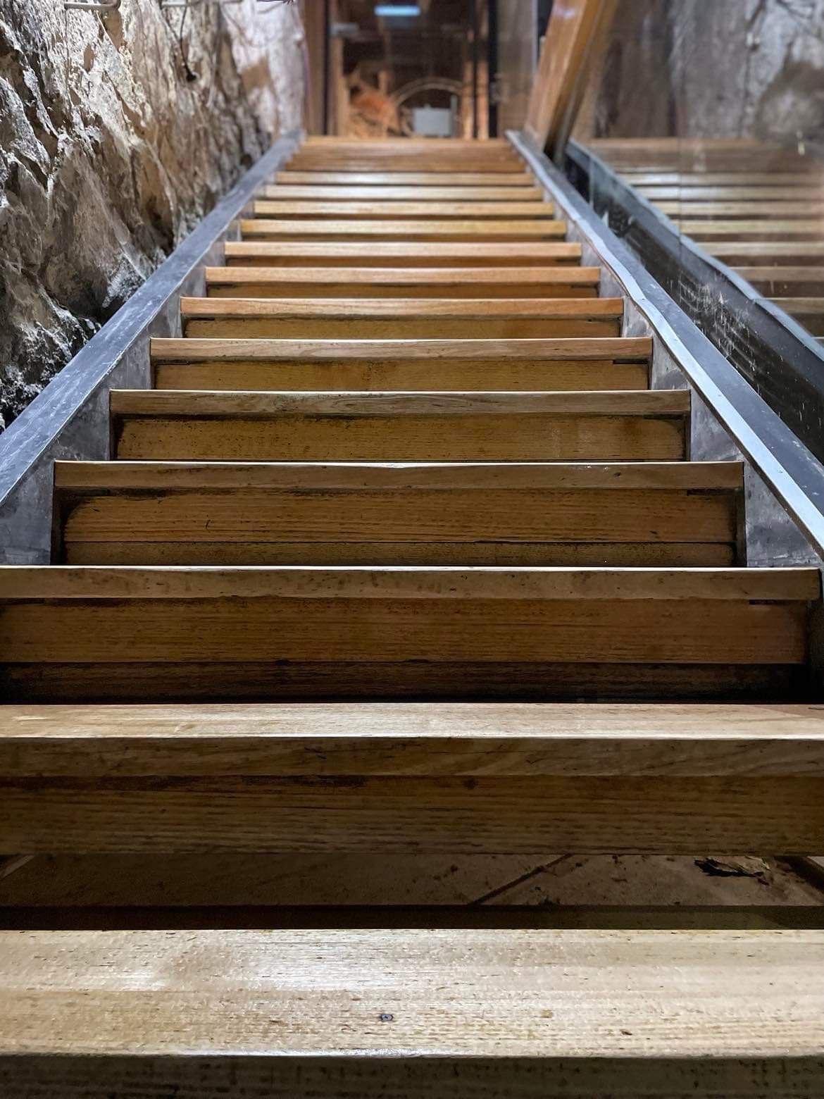 A Set of Wooden Stairs Leading Up to a Stone Wall — Evoke Building Group In Ballarat Central, VIC