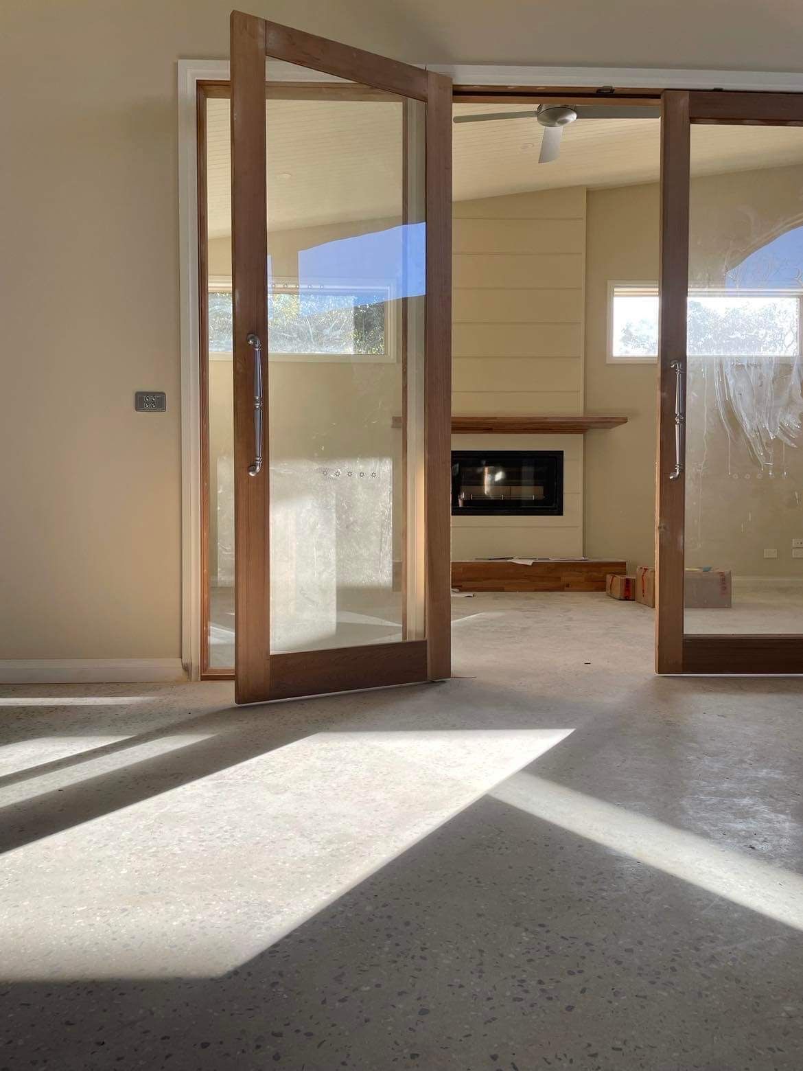A Living Room With Sliding Glass Doors and a Fireplace — Evoke Building Group In Ballarat Central, VIC