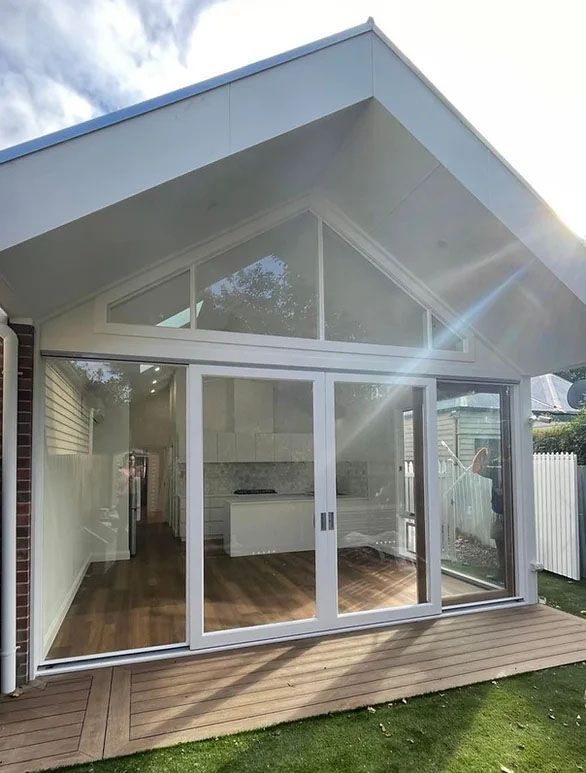 A house with a lot of windows and sliding glass doors.