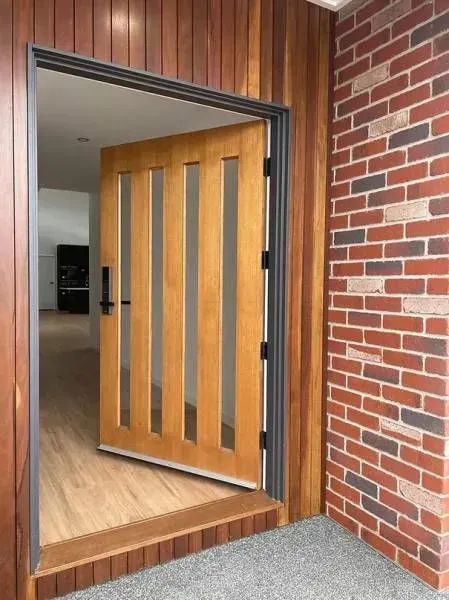 A Wooden Door is Open to a Brick Wall — Evoke Building Group In Ballarat Central, VIC