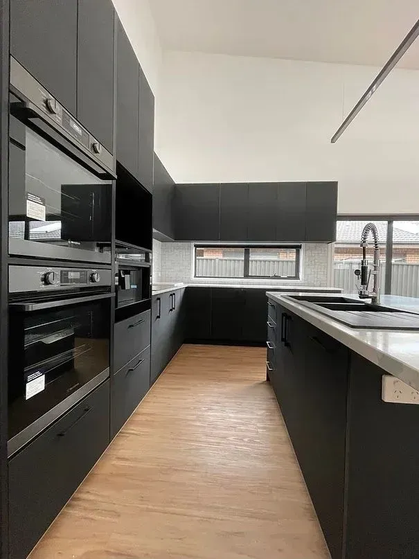 A Kitchen With Black Cabinets and Stainless Steel Appliances — Evoke Building Group In Ballarat Central, VIC