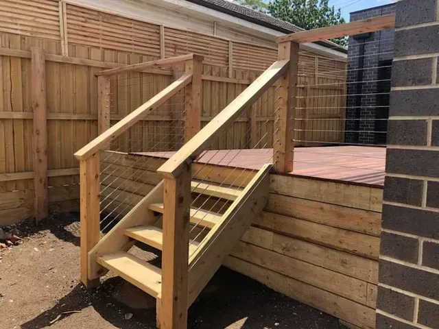 A Wooden Deck With Stairs and a Wire Railing — Evoke Building Group In Ballarat Central, VIC
