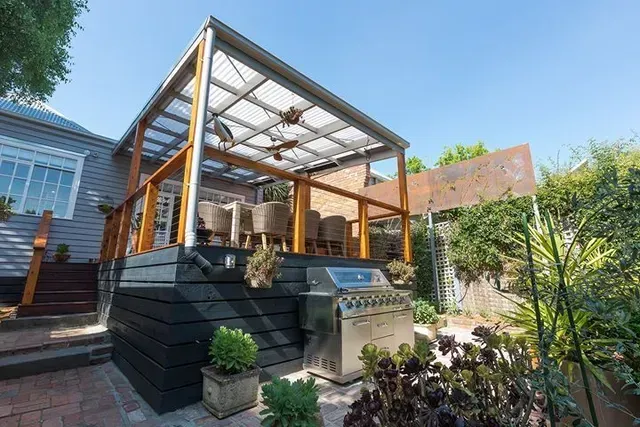 A Patio With a Grill and Chairs Under a Pergola — Evoke Building Group In Ballarat, VIC