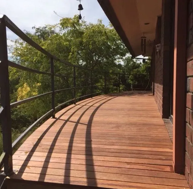 A Wooden Deck With a Railing and Trees in the Background — Evoke Building Group In Bendigo, VIC