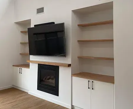 A Living Room With a Fireplace, Shelves, and a Flat Screen Tv — Evoke Building Group In Ballarat Central, VIC