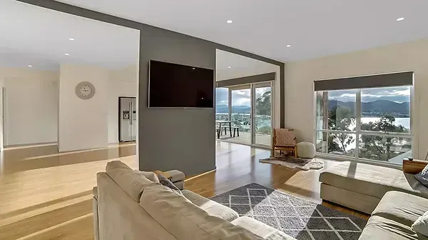 A Living Room With a Couch, Television, and Large Windows — Evoke Building Group In Ballarat Central, VIC