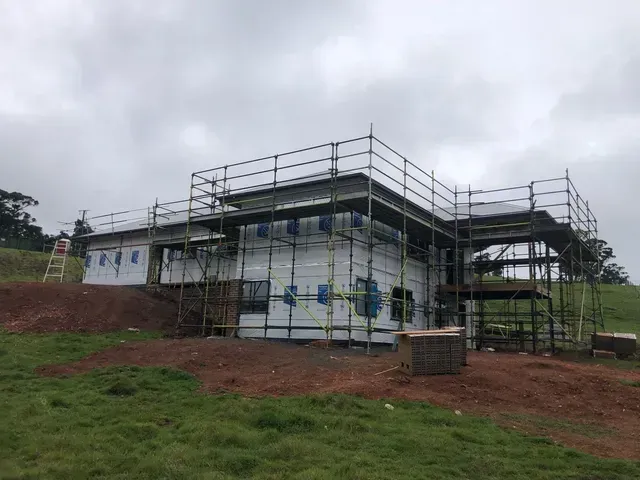 A House is Being Built in a Field With Scaffolding Around It — Evoke Building Group In Daylesford, VIC