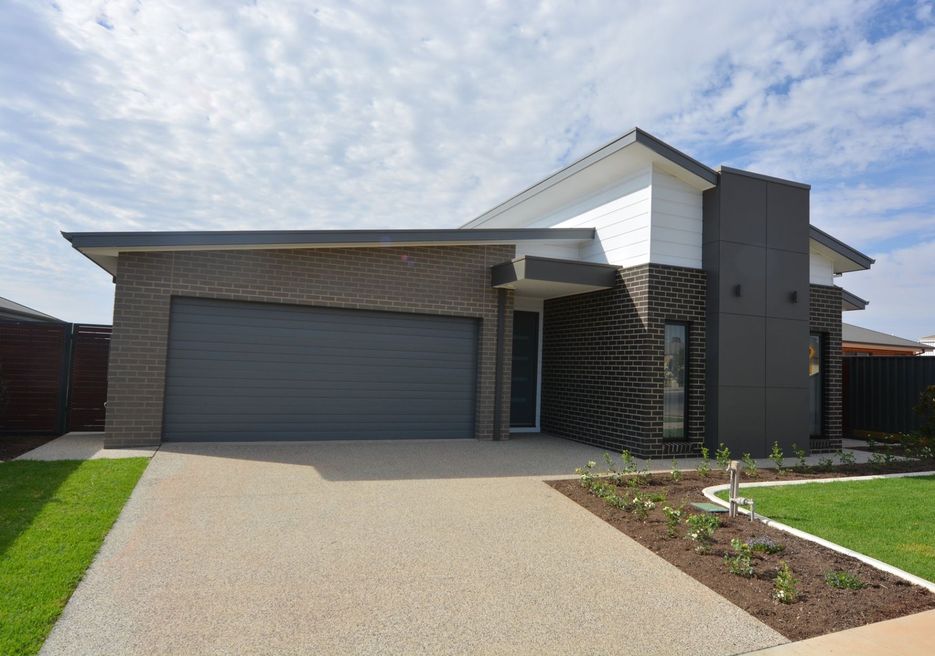 A Modern Brick House With a Gray Garage Door — Evoke Building Group In Ballarat Central, VIC