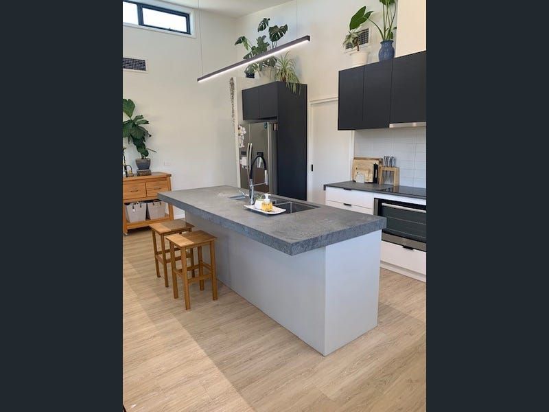 A Kitchen With a Large Island and Stools — Evoke Building Group In Ballarat Central, VIC