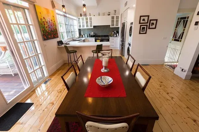 A Dining Room Table With a Red Table Runner and a Bowl on It — Evoke Building Group In Daylesford, VIC