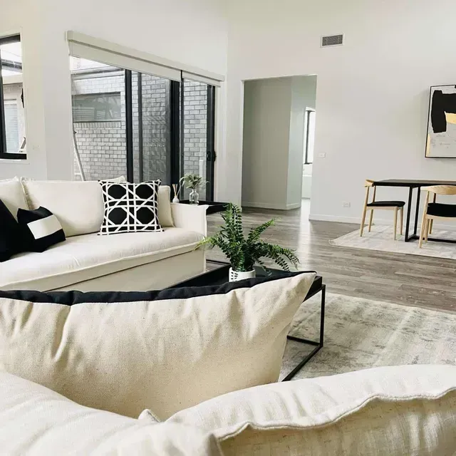 A Living Room With a White Couch and Black and White Pillows — Evoke Building Group In Ballarat Central, VIC