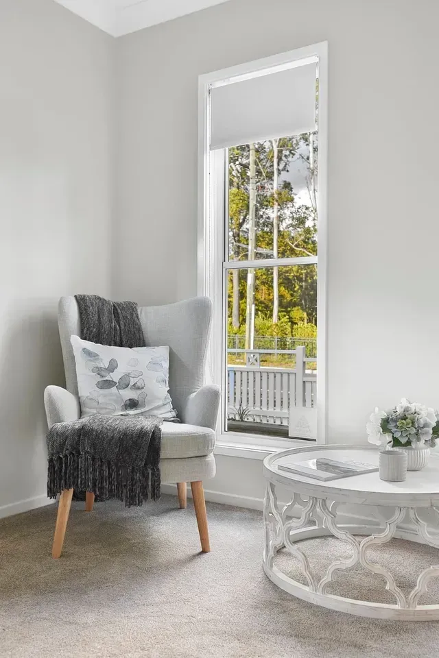 A Living Room With a Chair and a Coffee Table in Front of a Window — Evoke Building Group In Ballarat Central, VIC
