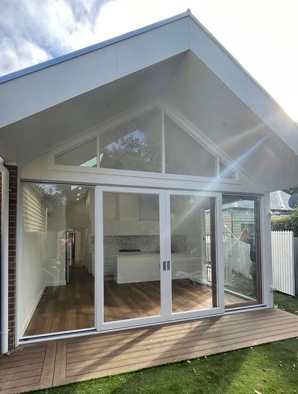 A Modern House With a Red Garage Door and a Purple Sky in the Background — Evoke Building Group In Ballarat Central, VIC
