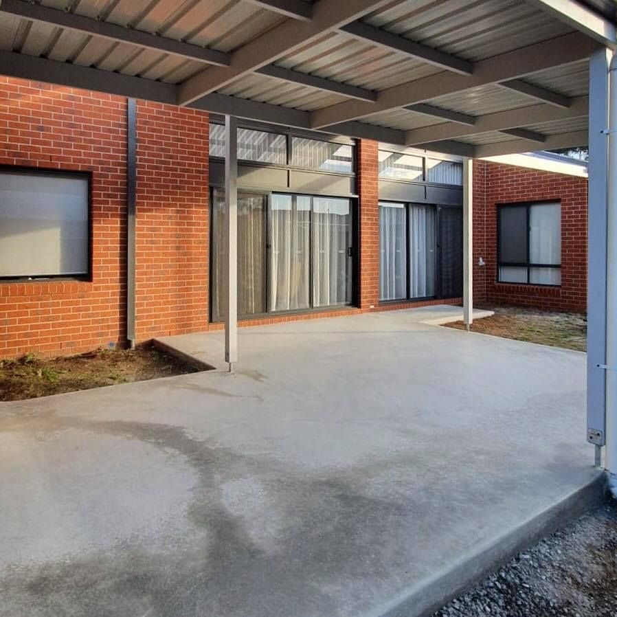 A Brick Building With a Covered Area in Front of It — Evoke Building Group In Ballarat Central, VIC