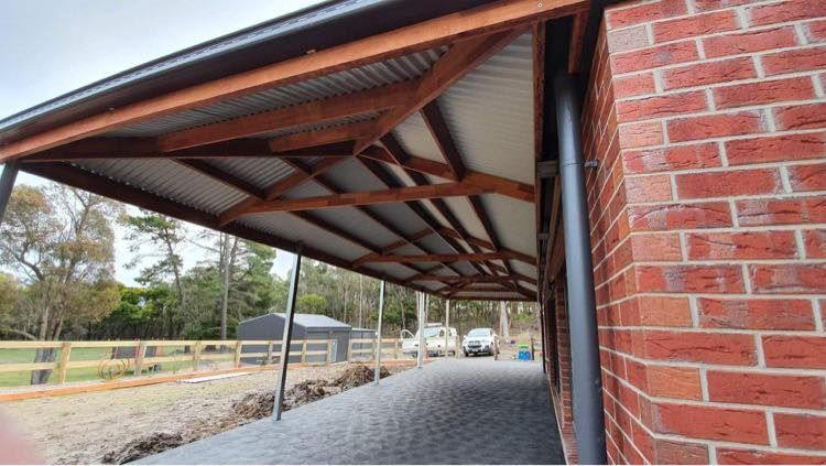 A Carport is Being Built on the Side of a Brick Building — Evoke Building Group In Ballarat Central, VIC