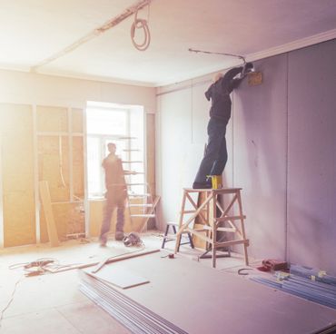 Workers are installing plasterboard (drywall)