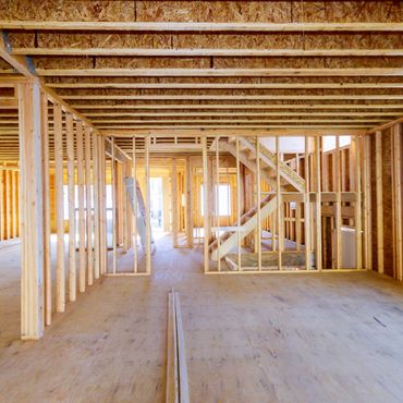 Building construction, wood framing new home under construction roof being built against blue sky