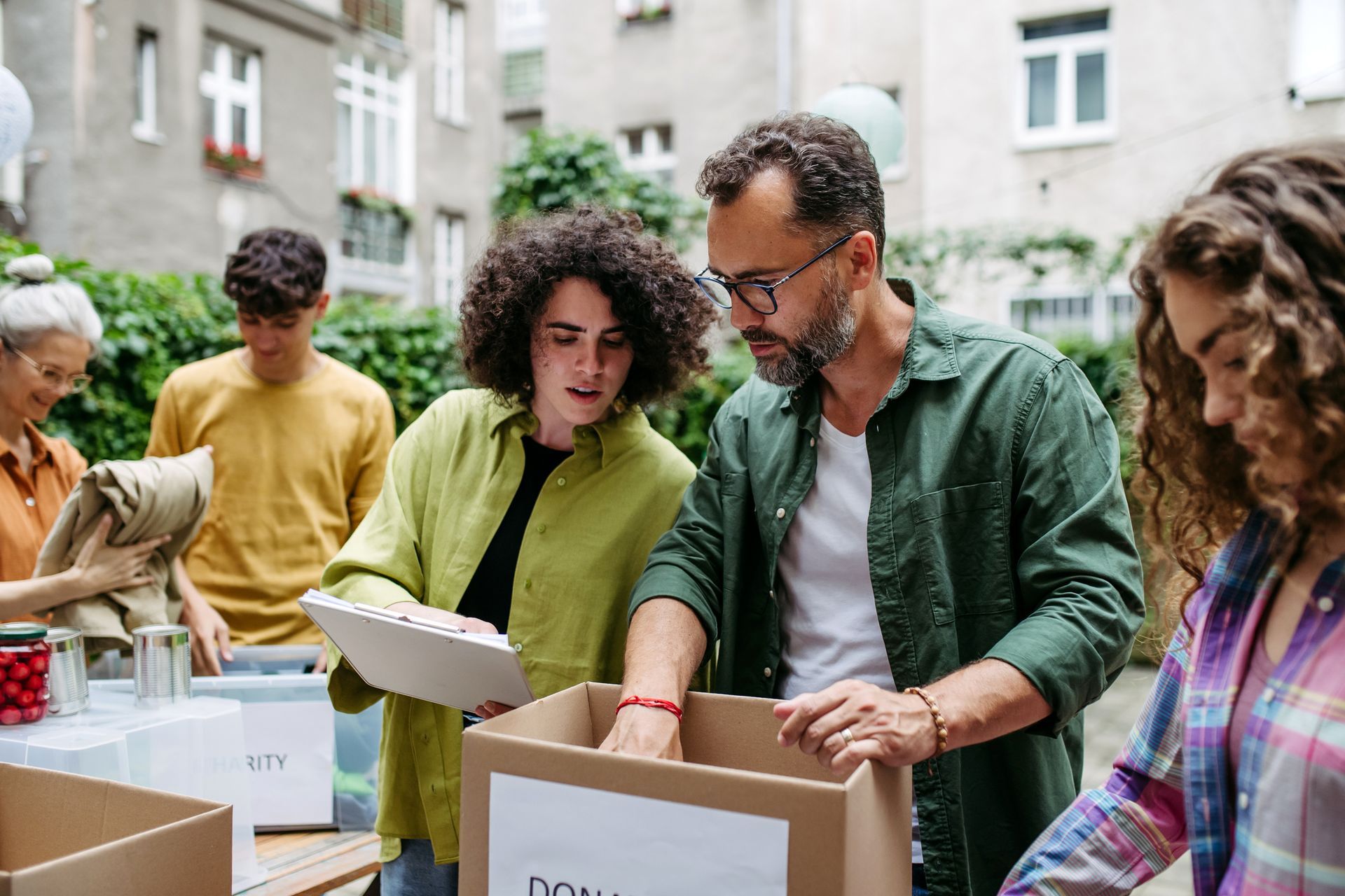 Persone che impacchettano le donazioni in scatole all'aperto.