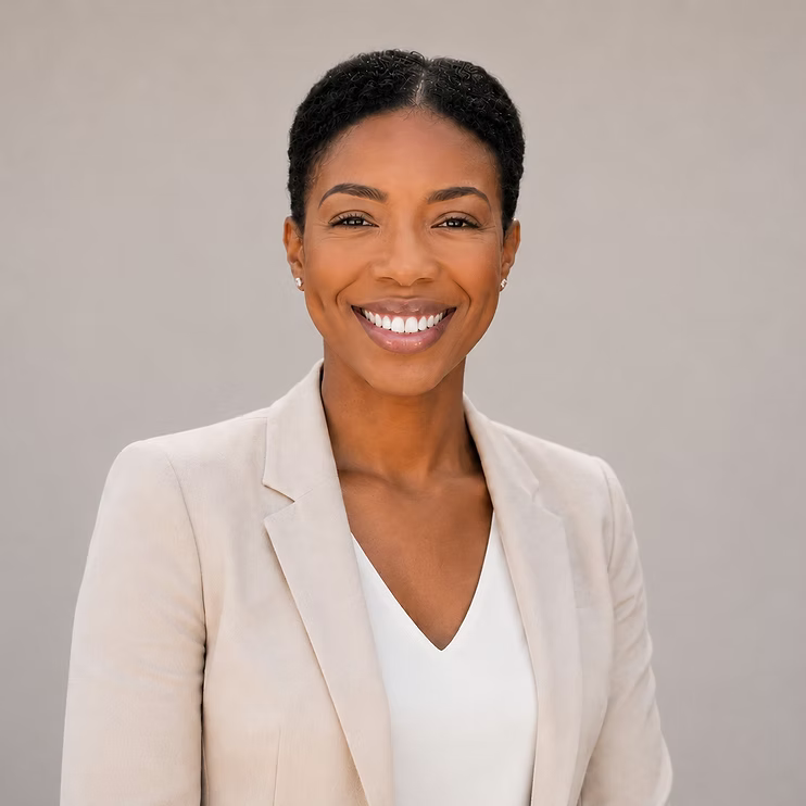 Smiling professional in a cream blazer against a neutral background