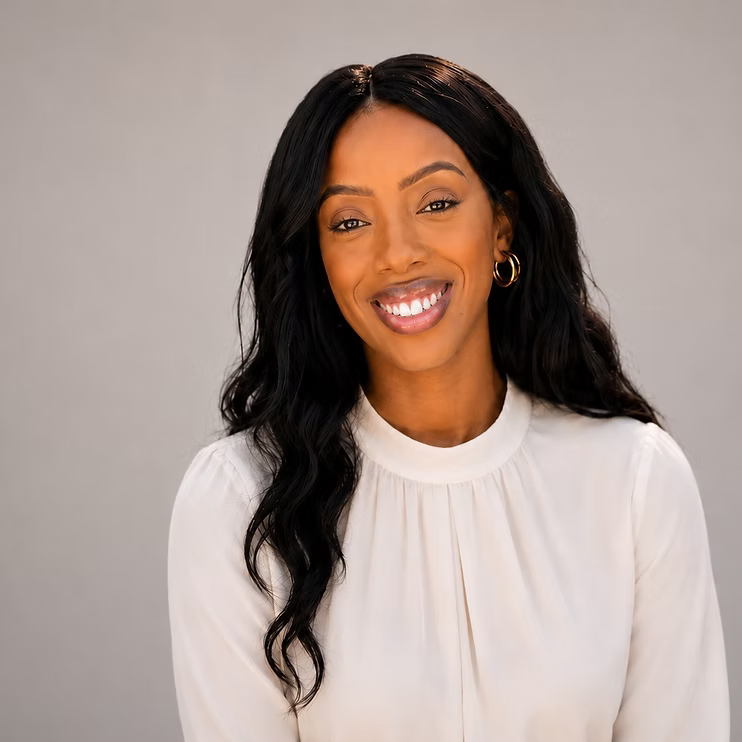 Portrait of a smiling woman in a white blouse against a neutral background