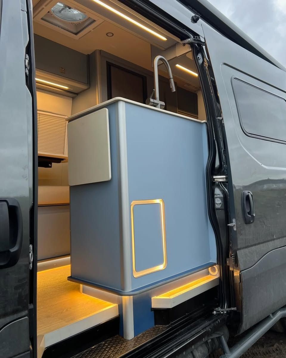 spacious blue cabinet inside a van with a lit interior and open sliding door