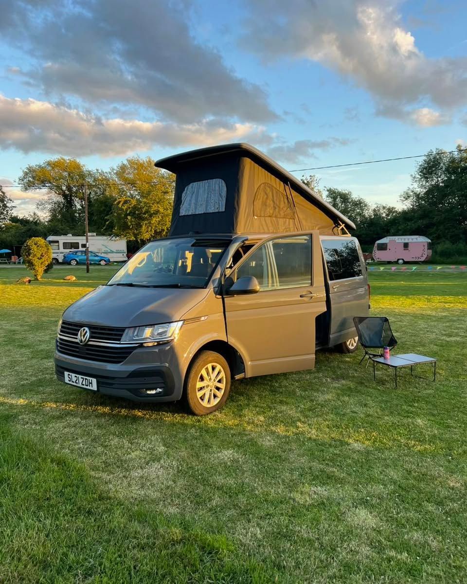 AMT campervan with an open pop top roof parked on grass at Download Festival