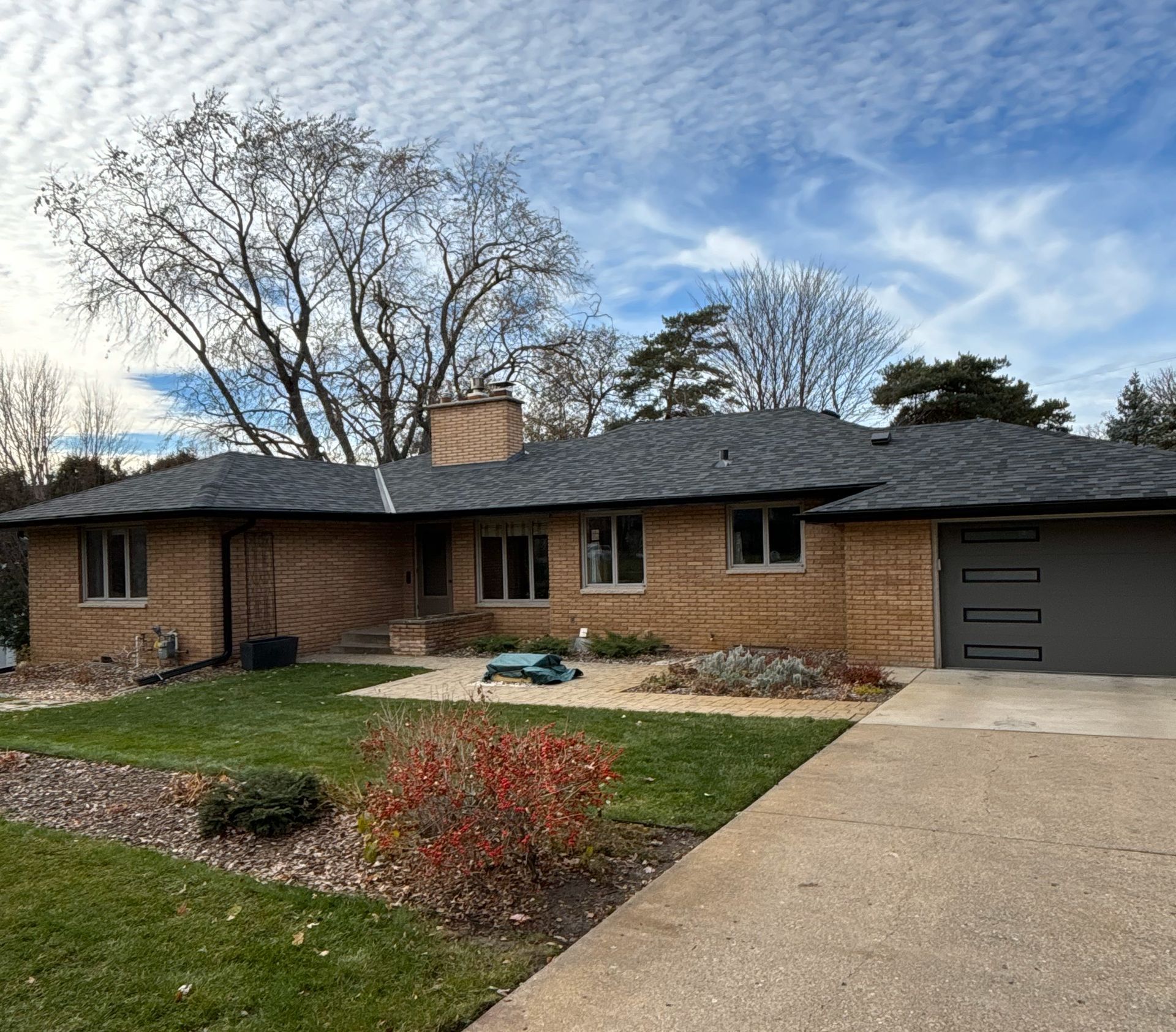A brick house with a gray roof and a garage