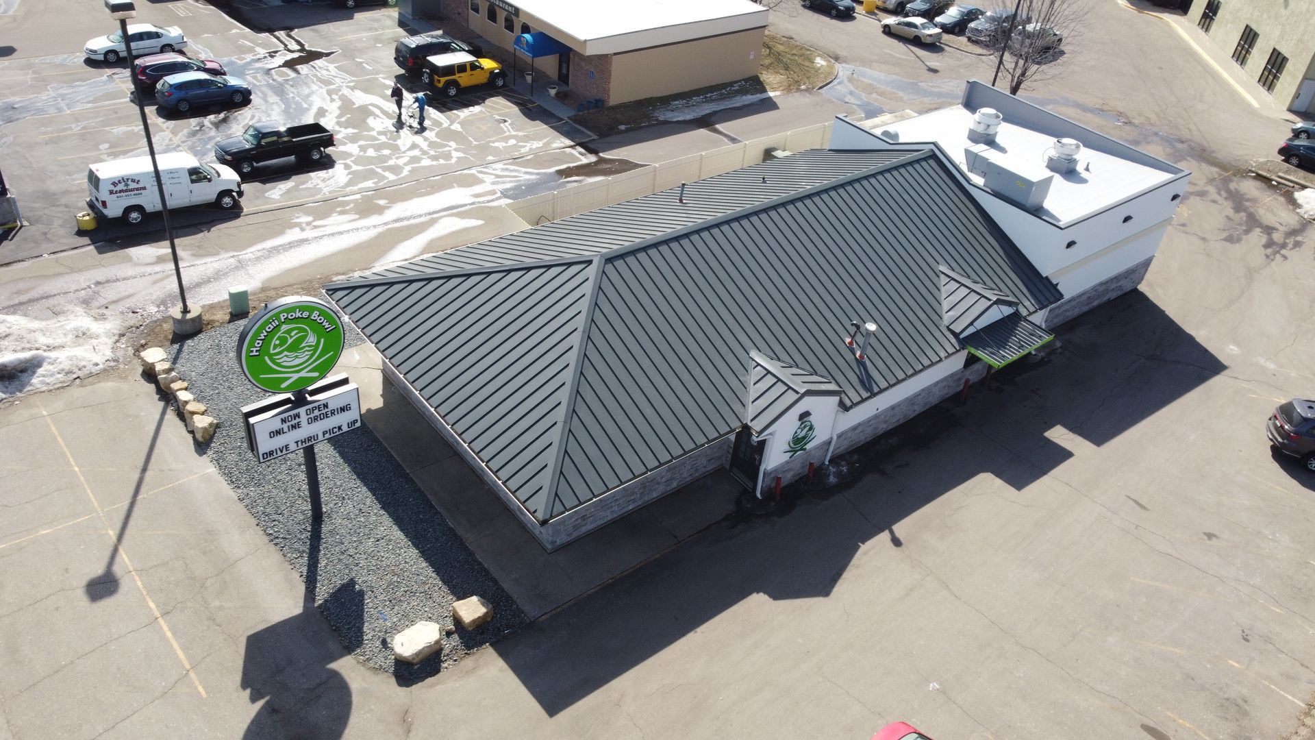 An aerial view of a restaurant with a black roof in a parking lot.