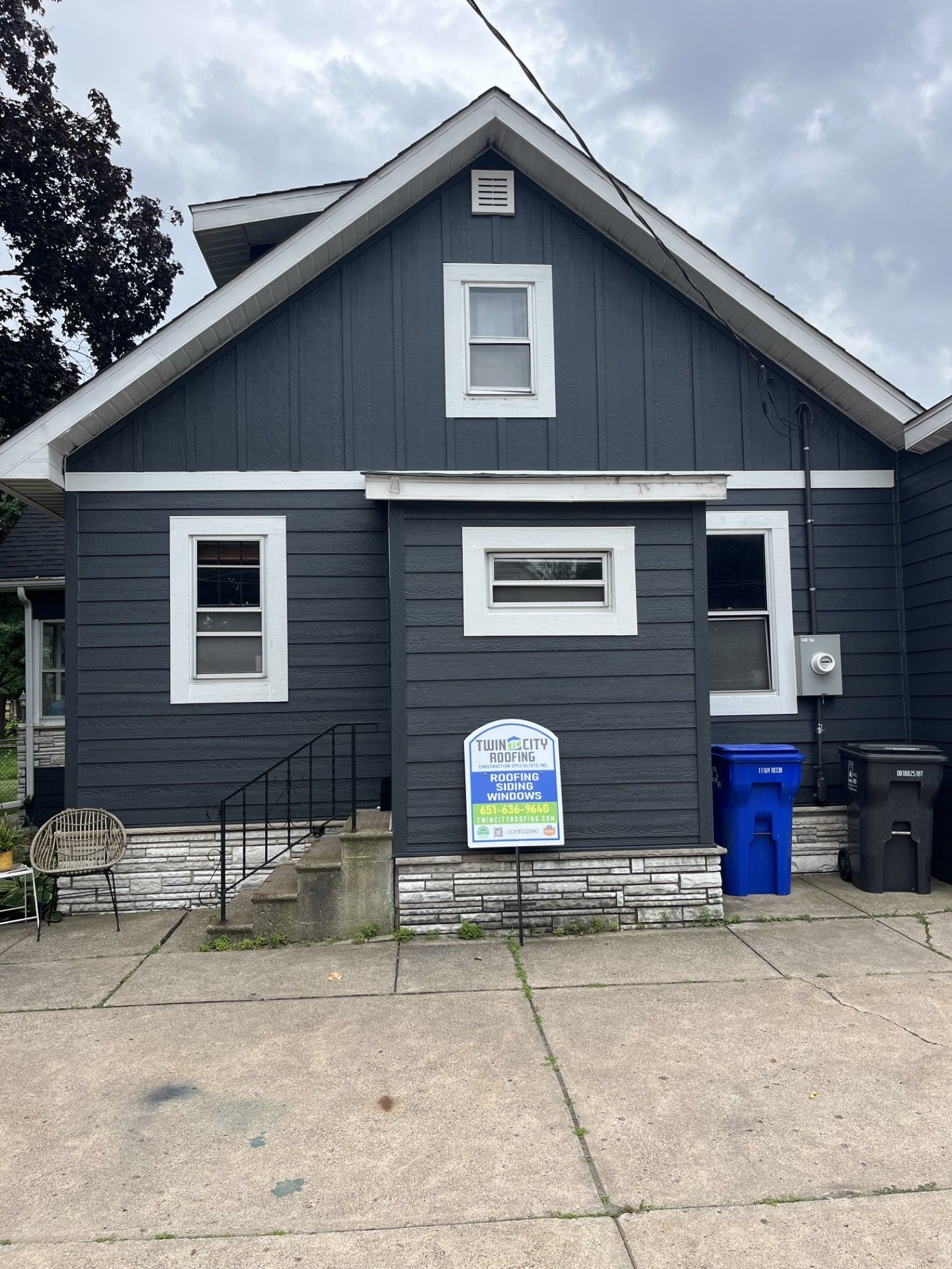Dark gray house with white window frames.