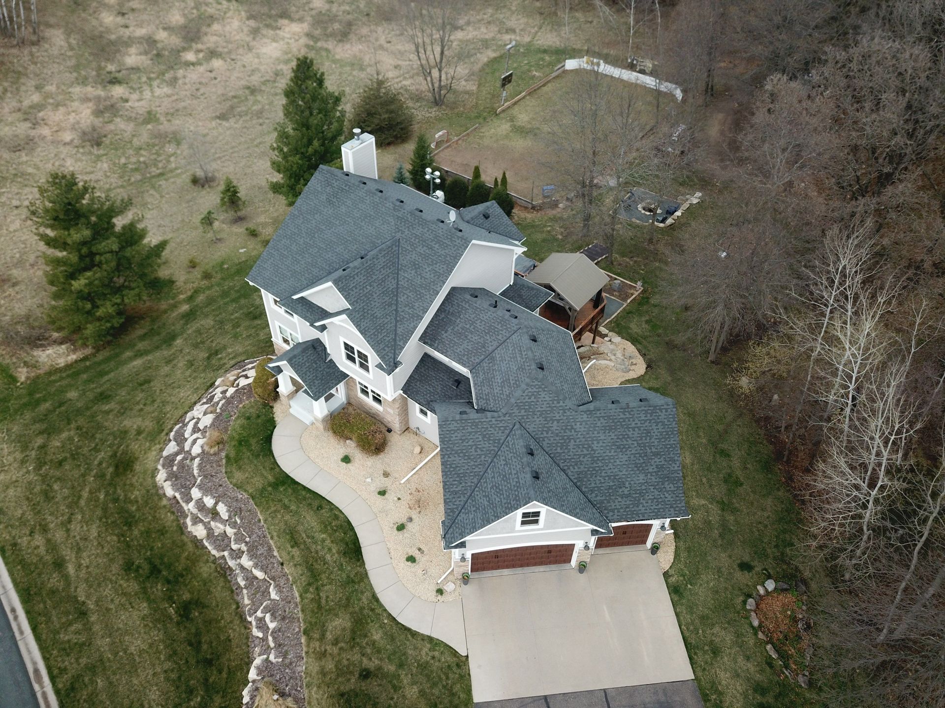An aerial view of a large house with a blue roof