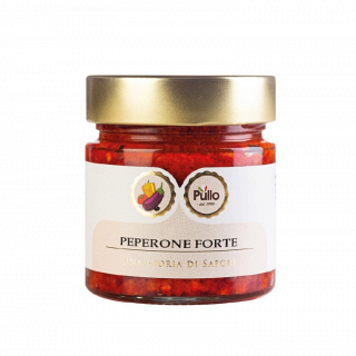 Vasetto di crema spalmabile al peperoncino Peperone Forte rosso con coperchio dorato ed etichetta bianca su sfondo bianco.