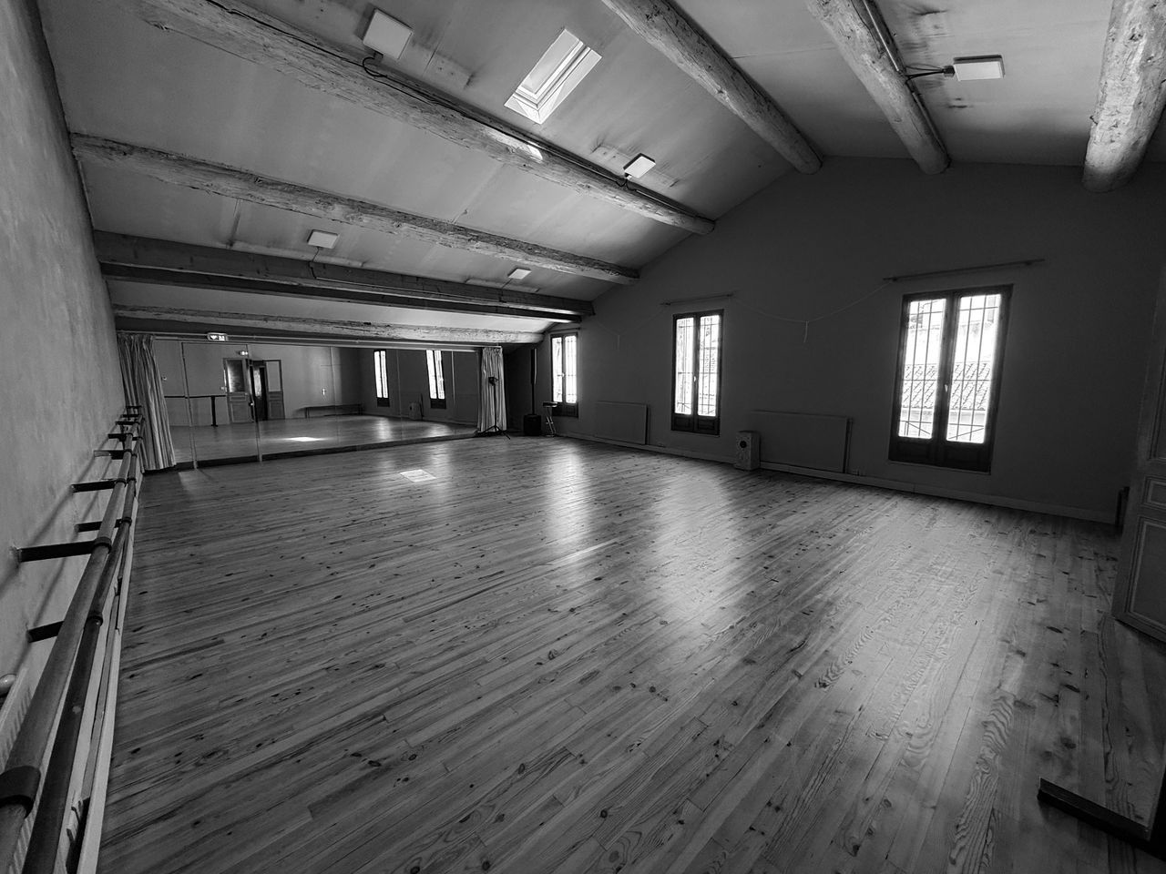The real dance studio at Le Studio du Faubourg, with wooden floor, mirrors, ballet barres and tall windows