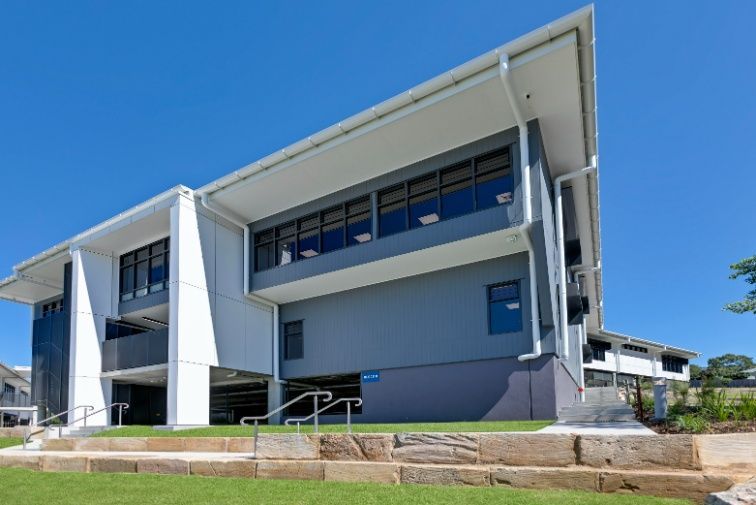 A Large Building With a Lot of Windows is Sitting on Top of Hillside — Architectural Glass Solutions QLD in Cooroy, QLD