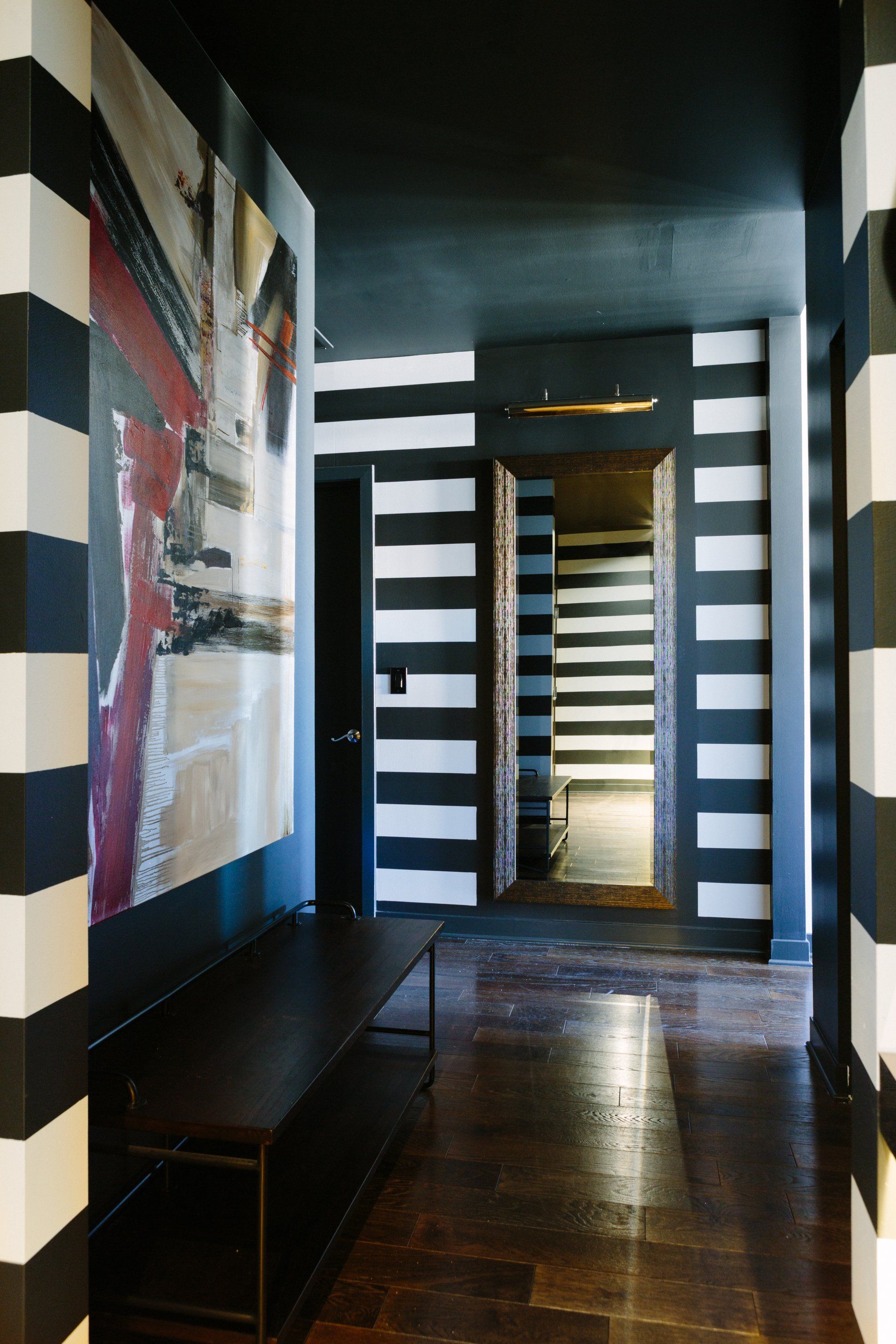 A hallway with black and white stripes on the walls